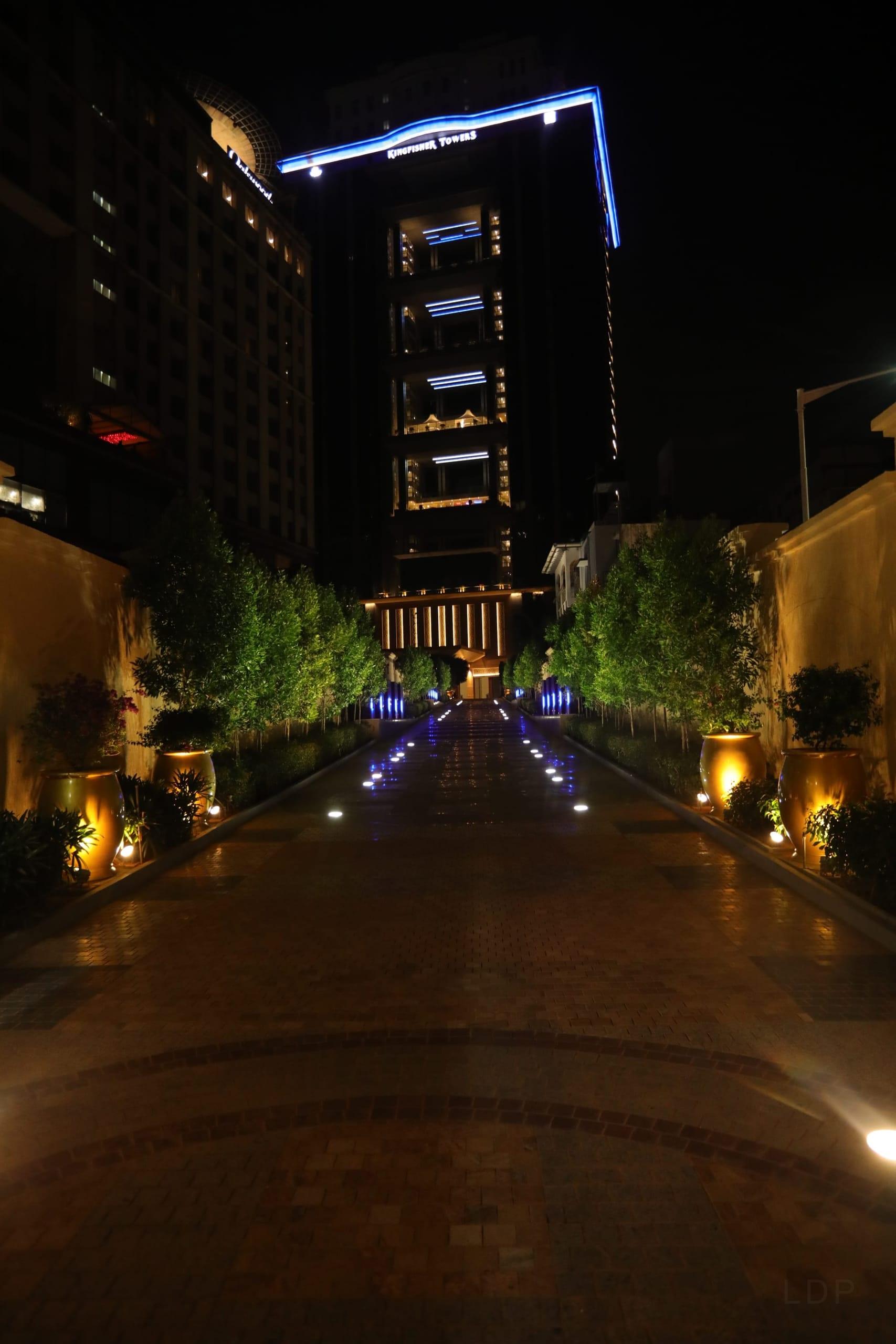 Blue, against the warm city. Depth built floor by floor, no light to the sky.